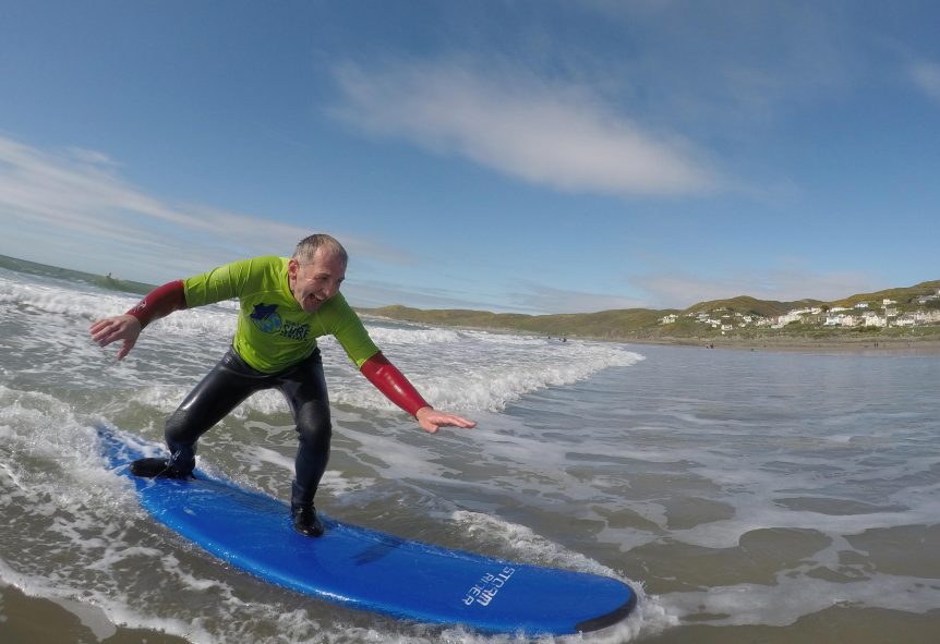 first time surfer enjoying the ride and getting free photos of his experience with Woolacombe Surf Centre