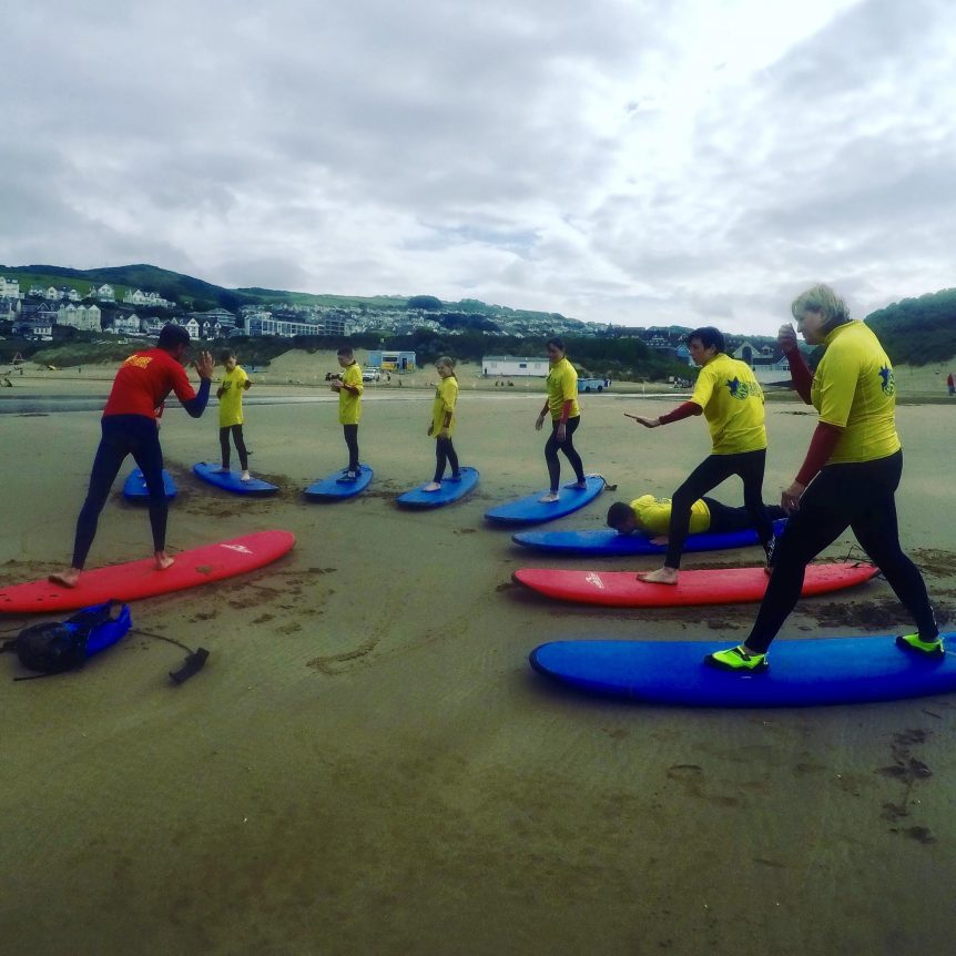 surf lesson on Woolacombe Beach, Woolacombe Bay North Devon. First time surfers learning the theory before hitting the waves