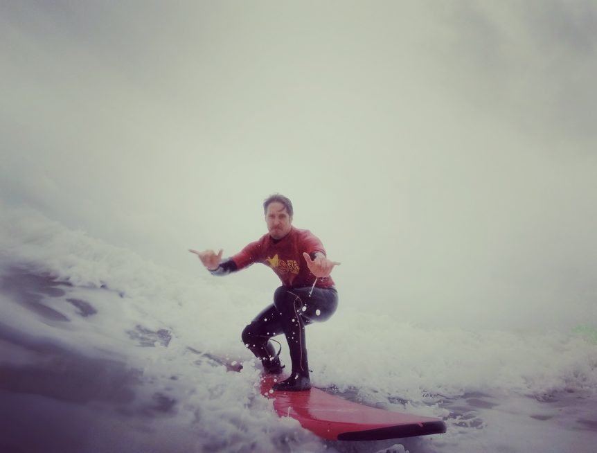 Woolacombe surf centre surf instructor Gary King surfing at Woolacombe Bay throwing a shaka